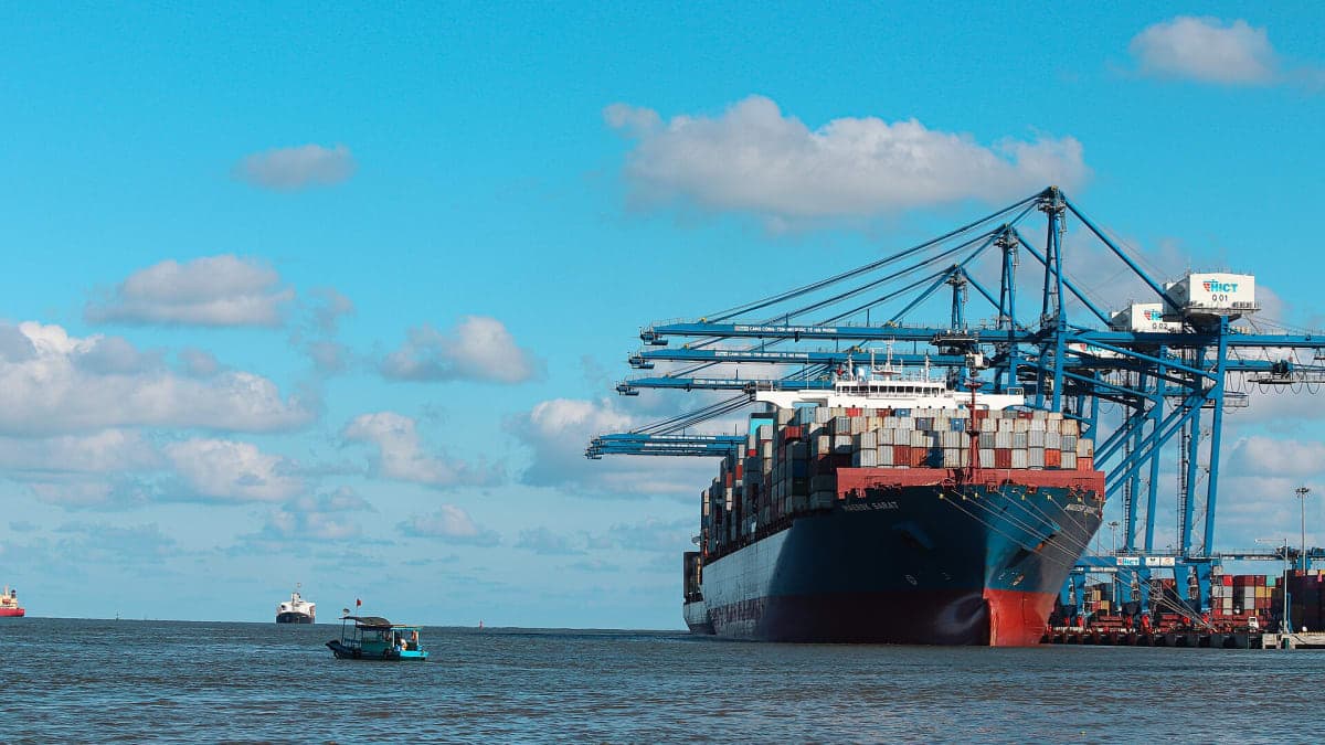 Container ship at an international container terminal loading vehicles for export