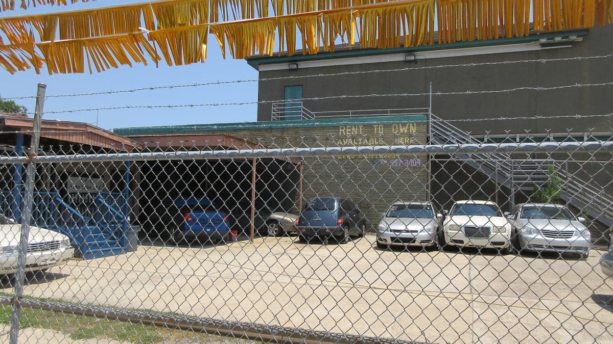 Used car lot with imported vehicles parked in rows for sale